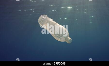 Rotes Meer, Ägypten. 17. Juni 2023. Einweg-Plastikflasche treibt unter Wasseroberfläche in Sonneneinstrahlung. Eine Plastikflasche wird ins Meer geworfen, treibt langsam in Wassersäule in Strahlen der Morgensonne, des Roten Meeres, Ägypten (Kreditbild: © Andrey Nekrasov/ZUMA Press Wire) NUR REDAKTIONELLE VERWENDUNG! Nicht für den kommerziellen GEBRAUCH! Stockfoto