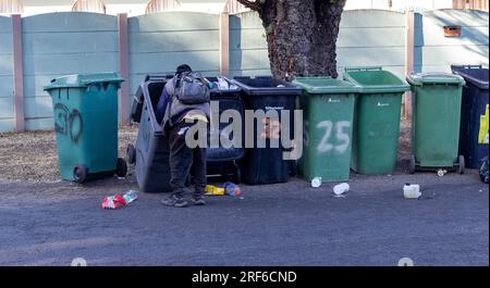 Johannesburg, Südafrika - ein unbekannter Schwarzer gräbt in Mülltonnen nach recyclingfähigem Material Stockfoto