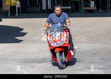 SAMUT PRAKAN, THAILAND, FEBRUAR 08 2023, Ein Mann fährt auf dem Marktplatz Motorrad Stockfoto