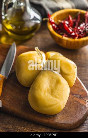 Geräucherter Scamorza-Käse auf dem Schneidebrett. Stockfoto