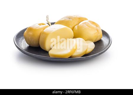 Geräucherter Scamorza-Käse auf Platte isoliert auf weißem Hintergrund. Stockfoto