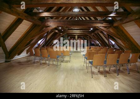Schloss Gomaringen, Innenraum im Dachgeschoss, Veranstaltungsraum, Stühle, Sitzgelegenheiten, Holzbalg, Weihnachtsbaum auf der Rückseite, ehemaliger Pfarrsitz von Johann Stockfoto