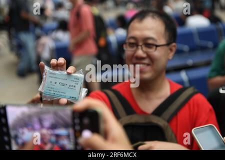 (230801) -- PEKING, 1. August 2023 (Xinhua) -- Ein Passagier zeigt ein Ticket, das er am 1. August 2008 gekauft hat, als die Peking-Tianjin Intercity Railway am Pekinger Südbahnhof in Peking, Hauptstadt von China, am 1. August 2023 in Betrieb genommen wurde. Die Peking-Tianjin Intercity Railway feierte ihren 15. Jahrestag der Eröffnung am Dienstag. Als erste Hochgeschwindigkeitsbahn (HSR) mit einer theoretischen Geschwindigkeit von 350 km/h in China beförderte die Peking-Tianjin Intercity Railway seit ihrer Inbetriebnahme insgesamt 340 Millionen Fahrgäste.bis 2022 hatte China 42.000 km betriebsbereite HSR und rangierte damit weltweit an erster Stelle Stockfoto