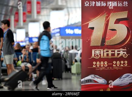 (230801) -- TIANJIN, 1. August 2023 (Xinhua) -- Passagiere warten auf den Einstieg in einen Zug der Intercity-Eisenbahn Peking-Tianjin am Bahnhof Tianjin in Nordchina Tianjin, 1. August 2023. Die Peking-Tianjin Intercity Railway feierte ihren 15. Jahrestag der Eröffnung am Dienstag. Als erste Hochgeschwindigkeitsbahn (HSR) mit einer theoretischen Geschwindigkeit von 350 km/h in China beförderte die Intercity-Eisenbahn Peking-Tianjin seit ihrer Inbetriebnahme insgesamt 340 Millionen Fahrgäste.bis 2022 hatte China 42.000 km betriebsbereite HSR und rangierte damit weltweit an erster Stelle. Und die Länge des Hochgeschwindigkeitsbahnsystems Stockfoto