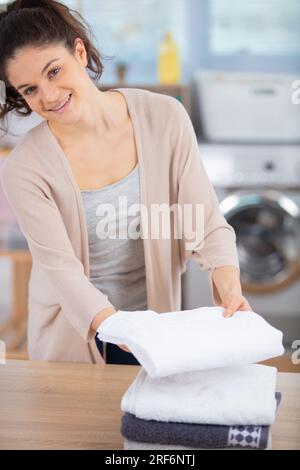 Frau faltet Kleidung in einem Hauswirtschaftsraum Stockfoto