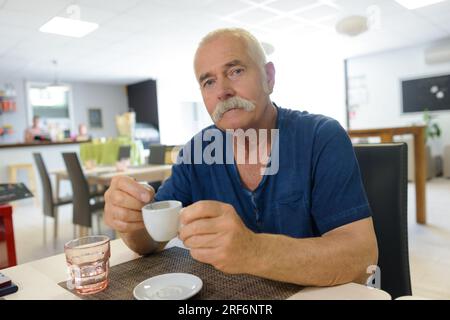 Ein älterer Mann, der Kaffee trinkt Stockfoto