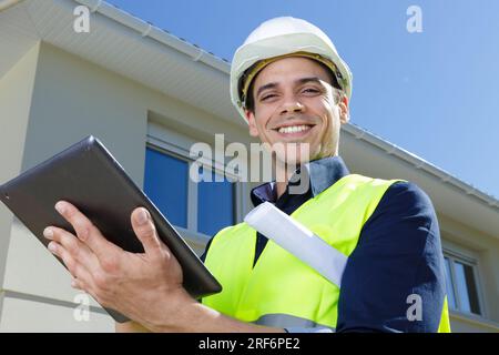 Fröhlicher Ingenieur, der eine Weste im Freien trägt Stockfoto