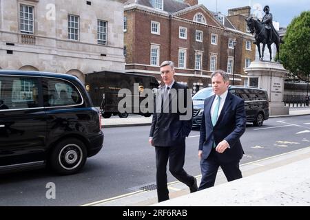 Die konservativen Abgeordneten Jacob Rees-Mogg (links) und Edward Argar gehen am Treasury Building in Whitehall in London vorbei, 25. Juli 2023. Foto: Rob Watkins Stockfoto