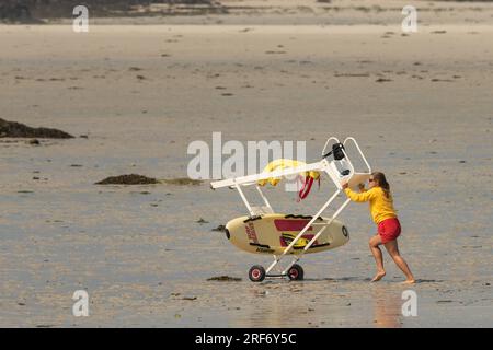 Lannilis, Frankreich - 8. August 2020: Eine arbeitende Frau am Strand in Frankreich, Surfbrett, Sommer Stockfoto