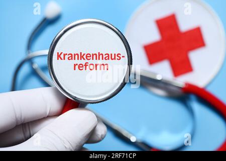 FOTOMONTAGE, Hand hält Stethoskop mit Aufschrift Krankenhausreform Stockfoto