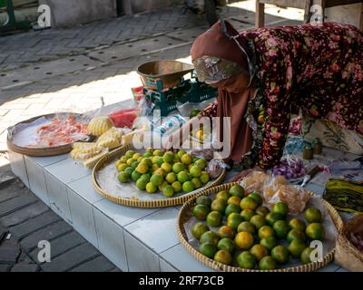 Yogyakarta-Indonesia, 19. Juli 2023: Eine alte indonesische Frau, die Obst auf einem traditionellen Markt in Yogyakarta, Indonesien, verkauft Stockfoto