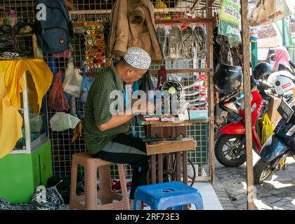 Yogyakarta-Indonesia, 19. Juli 2023: Ein alter indonesischer Schneider auf dem traditionellen Markt, in Yogyakarta, Indonesien Stockfoto