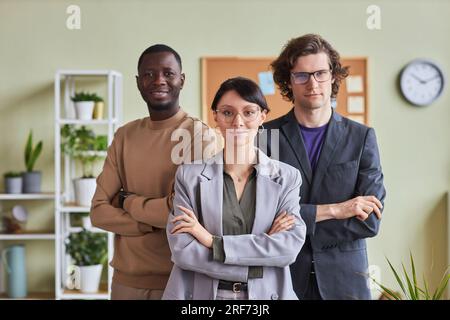 Taille hoch Porträt vielfältige Gruppe junger Leute im Büro posieren selbstbewusst mit verschränkten Armen und schauen in die Kamera Stockfoto