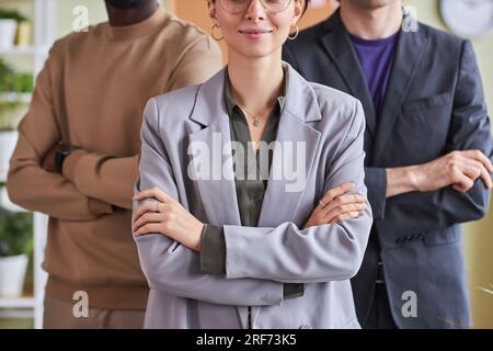 Nahaufnahme eines professionellen Business-Teams im Büro, das selbstbewusst mit verschränkten Armen posiert Stockfoto