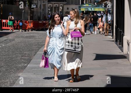 Zwei Käufer in der Bond Street mit ihren Liberty-Taschen am 7. Juli 2023 in London, Großbritannien, im exklusiven Bereich von Mayfair. Traditionell wohlhabende Teile von West London haben sich zu wohlhabenden Spielplätzen der Superreichen entwickelt, mit Zuströmen von ausländischem Geld, insbesondere aus dem Nahen Osten, Russland und China. Jüngsten Untersuchungen zufolge sind in der britischen Hauptstadt mehr Menschen mit hohem Nettowert und ultrahohem Nettowert als in jeder anderen Stadt der Welt zu Hause. Stockfoto