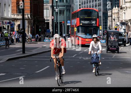 Radfahrer in der City of London, die am 6. Juli 2023 in London, Vereinigtes Königreich, mit Bussen des öffentlichen Nahverkehrs interagierten. Radfahren ist ein sehr beliebtes Verkehrsmittel in der Hauptstadt, da die Menschen versuchen, öffentliche Verkehrsmittel zu vermeiden, Geld zu sparen, fit zu werden und Zeit zu sparen. Stockfoto