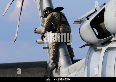 230623-N-N3764-1004 KARIBISCHE SEE (23. Juni 2023) – Naval Aircrewman 3. Class William McCauley, angeschlossen an Helicopter Sea Combat Squadron (HSC) 28, führt vor dem Flug Kontrollen an einem MH-60s Sea Hawk Hubschrauber an Bord des Küstenschiffes USS Detroit (LCS 7) der Freedom-Klasse durch, während er in der Karibik unterwegs ist. Die USS Detroit wird zur Unterstützung der Mission des Befehlshabers der Task Force 45 (CTF-4.) in das US-Flottengebiet entsandt. Die Mission umfasst kombinierte Marineeinsätze, den Aufbau von Partnerschaften und die Tätigkeit als Dienstleister für die Gemeinsame Interinstitutionelle Task Force Süd durch Unterstützung von Gegenmaßnahmen Stockfoto