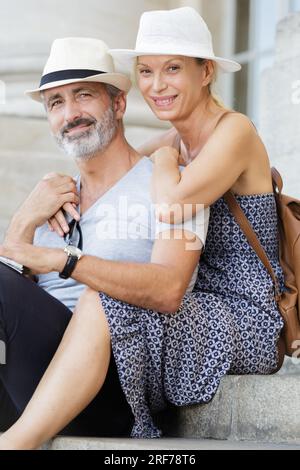 Ältere Touristen saßen auf Stufen eines architektonischen Gebäudes Stockfoto