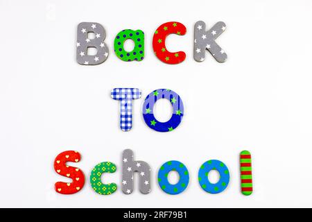 Text „Zurück zur Schule“ mit bunten Fliesen. Banner mit Buchstaben auf weißem Hintergrund. Stockfoto