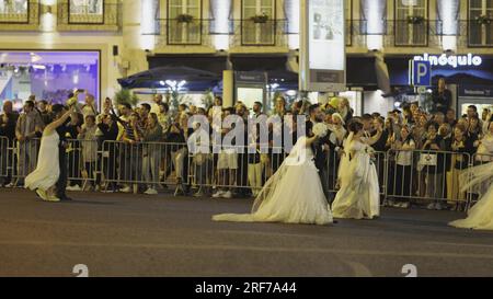 12. juni 2023 Rua da Liberdade, Lissabon Portugal - Santo Antonio Festival - Brautparade - Frauen, die in weißen Kleider die Straße entlang laufen. Mitten im Bild Stockfoto