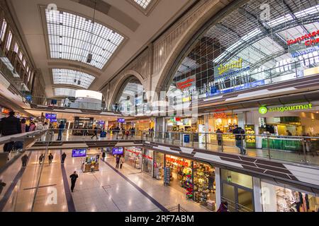 Leipzig, Deutschland - 20. Februar 2023: Leipziger Hauptbahnhof. Bahnhof oder Hauptbahnhof der Deutschen Bahn. Bahnhalle mit Geschäften in zwei f Stockfoto