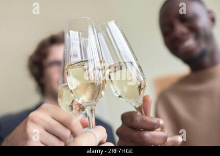 Nahaufnahme von Leuten, die im Büro Champagnergläser klingeln und während der Party im Büro Toasten, Kopierraum Stockfoto