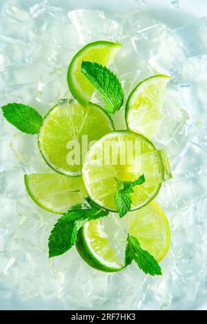 Frische, saftige Limettenkeile mit Minze und Eis. Draufsicht, Nahaufnahme. Stockfoto