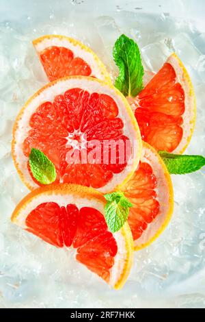 Frische, saftige Grapefruitscheiben mit Minze und Eis. Draufsicht, Nahaufnahme. Stockfoto