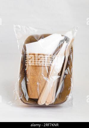 Umweltfreundliche Einwegverpackungen für Lebensmittel. Braune Papierbehälter, Getränkegläser, Gabeln und Messer. Modell, Vorlage. Stockfoto