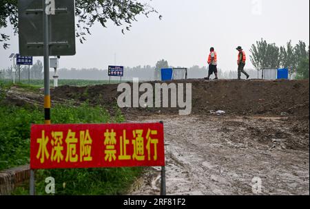 (230801) -- TIANJIN, 1. August 2023 (Xinhua) -- Freiwillige prüfen an einem Ufer entlang eines Flusses im Dorf Shaoqidi der Stadt Huanghuadian, Bezirk Wuqing der Gemeinde Tianjin, Nordchina, 1. August 2023. Die nordchinesische Gemeinde Tianjin sagte, dass sie am Dienstag mehr als 35.000 Menschen aus Gebieten verlegt habe, die durch den Yongding-Fluss überschwemmt werden, der bei intensiven Regenfällen geschwollen ist. Die Stadt, die an Peking grenzt, hat am Dienstag ihre Notfallmaßnahmen für Hochwasser von Stufe III auf Stufe I, die höchste Ebene, erhöht, so Tianjins Hauptquartier für Hochwasserschutz und Dürre. (Xinhua/Sun Fany Stockfoto