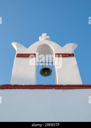 Niedriger Winkel mit weißgetünchtem Glockenturm und blauem Himmel im Hintergrund, Ia (Oia), Santorin, Griechenland Stockfoto