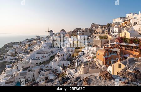 Häuser, Villen und Windmühlen an den Klippen im Dorf Oia (Ia), von der Burg Kasteli aus gesehen, Santorin, Griechenland Stockfoto