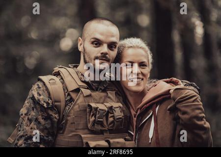 Glückliche Frau, die verliebt ist und einen Heldensoldaten umarmt Stockfoto