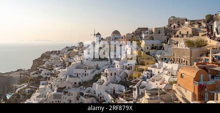 Häuser, Villen und Windmühlen an den Klippen im Dorf Oia (Ia), von der Burg Kasteli aus gesehen, Santorin, Griechenland Stockfoto