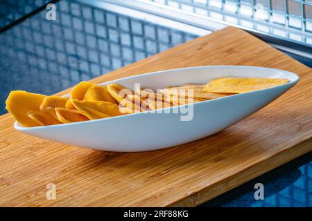 Küchentisch mit getrockneter Mango in Schüssel Stockfoto