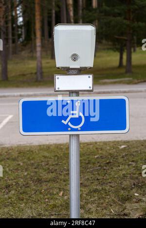 Behindertenparkplatz-Schild unter der Steckdose für die Fahrzeugheizung. Stockfoto