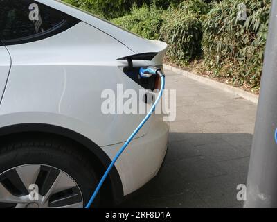 Köln, Deutschland. 27. Juli 2023. Ein Elektroauto an einer Ladestation auf einem Parkplatz aufgeladen wird, Ladekabel im Ladestecker Ladestation Schnellladestation Ladestation Ladestation für Elektroauto Elektromobilität E-Car Ladestecker Ladekabel Kfz-Stecker Power Car Power Column Power Charging Station Power Electric Mobility Technology Charging Power Grid Credit: Horst Galuschka/dpa/Alamy Live News Stockfoto
