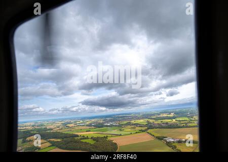 Blick aus einem Hubschrauberfenster über die Landschaft Großbritanniens mit wolkenlosem Himmel. Stockfoto