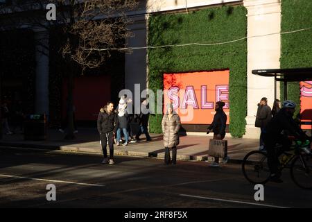 Am zweiten Weihnachtsfeiertag ist vor dem Geschäft Selfridges ein „Sale“-Logo zu sehen, wenn die Menschen auf der Oxford Street in London spazieren gehen. Stockfoto