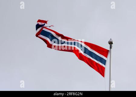 Ein norwegischer Wimpel, Flagge, flattert im Wind, fixiert auf einer Fahnenstange gegen den hellen Himmel. Andenes, Andøya, Vesterålen-Archipel, Nordland, Norwegen Stockfoto