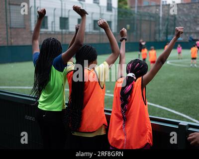 Drei junge Mädchen jubeln ihrem Football-Team zu. Stockfoto