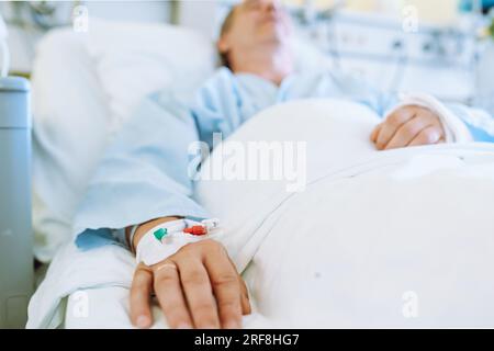 Männlicher Patient nach Verletzung oder Operation auf der Krankenhausstation Stockfoto