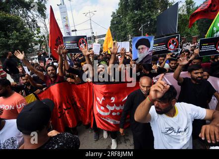 (7/27/2023) SRINAGAR, JAMMU UND KASCHMIR, INDIEN - 2023/07/27: Schiitische Moslems aus Kaschmir halten Porträts des iranischen Führers und des Korans, die die Verbrennung des islamischen Heiligen Korans in Schweden während einer Prozession am 8. Tag Muharram verurteilen. Nach einem Verbot von 34 Jahren durften Muharram-Prozessionen in Srinagar eine traditionelle Route passieren. Muharram ist der erste Monat des islamischen Kalenders. Es ist einer der heiligsten Monate im islamischen Kalender. Schiitische Moslems gedenken Muharram als einen Monat der Trauer im Gedenken an das Märtyrertum des islamischen Propheten Muhammad's grands Stockfoto