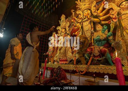 Howrah, Westbengalen, Indien - 3. Oktober 2022 : Hindu-Priester, die die Göttin Durga mit Panchapradip und Chamor anbeten. Ashtami Puja aarati. Stockfoto