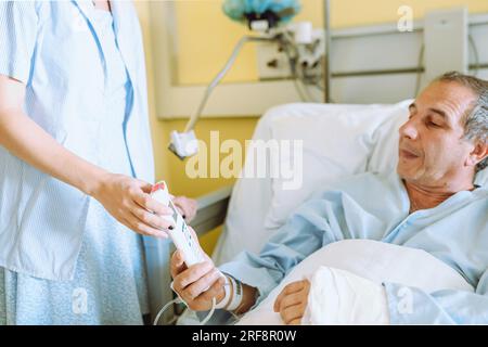 Männlicher Patient nach Verletzung oder Operation auf der Krankenhausstation Stockfoto