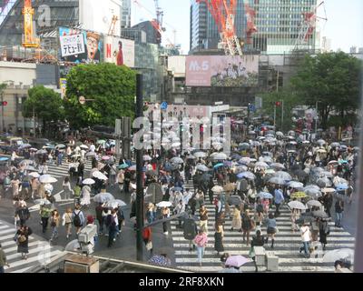 Modernes Japan: Die geschäftigste Fußgängerüberquerung der Welt in Shibuya in Tokio, umgeben von Neonlichtern, Werbung und den Kränen von Baustellen. Stockfoto