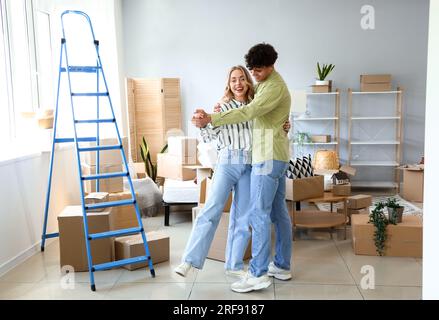 Ein junges Paar tanzt am Umzugstag im Schlafzimmer Stockfoto