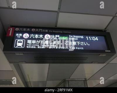 Das elektronische Schild am Bahnsteig der U-Bahn in Tokio informiert den Zug um 11:04 Uhr nach Roppongi, Daimon nähert sich. Stockfoto