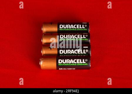 Salvador, Bahia, Brasilien - 30. Juli 2023: Vier aufladbare Batterien der Marke Duracell, isoliert auf rotem Hintergrund. Stockfoto