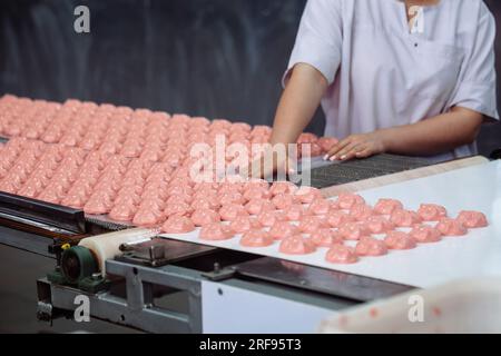 Konditorei, die Marshmallows auf dem Förderband sortiert. Stockfoto